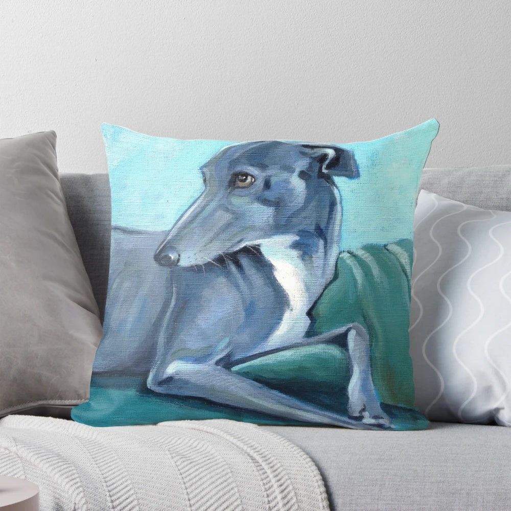 A blue and white decorative pillow featuring a greyhound or whippet breed dog design.