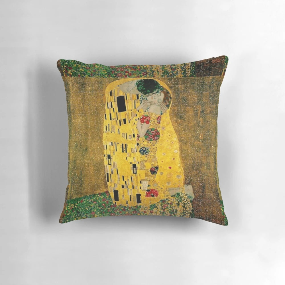 A beautiful decorative pillow featuring Gustav Klimt's iconic painting "The Kiss" depicting a couple in a loving embrace.