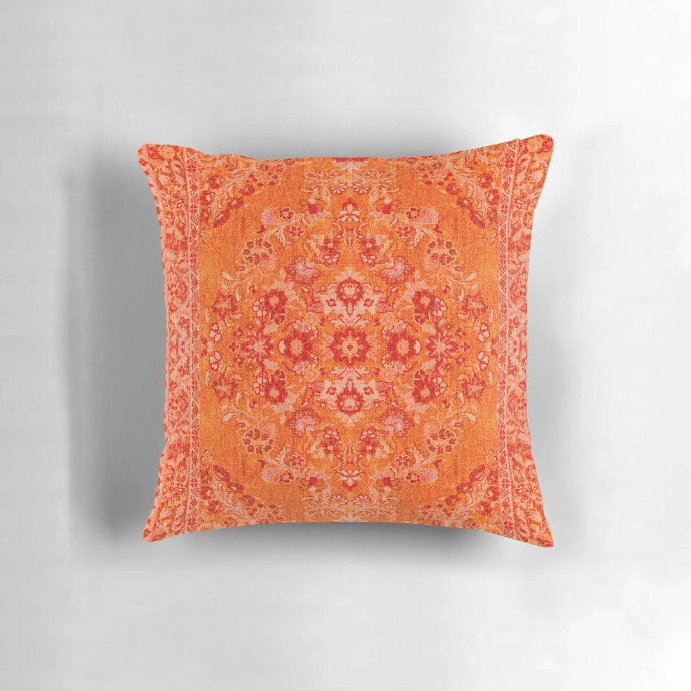 Closeup of a vibrant orange and blue patterned Moroccan-style bohemian throw pillow