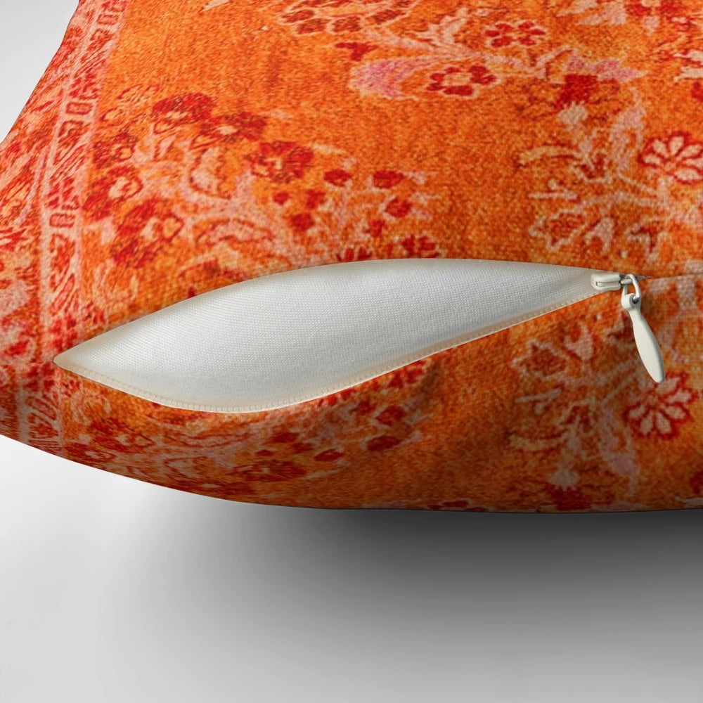 Closeup of a vibrant orange and blue patterned Moroccan-style bohemian throw pillow
