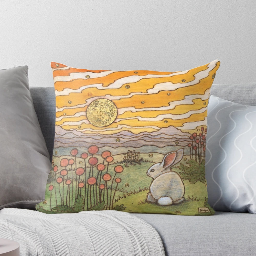 A handcrafted rabbit/bunny pillow featuring a beautiful sunset landscape design with mountains, created using pyrography and natural pigments.