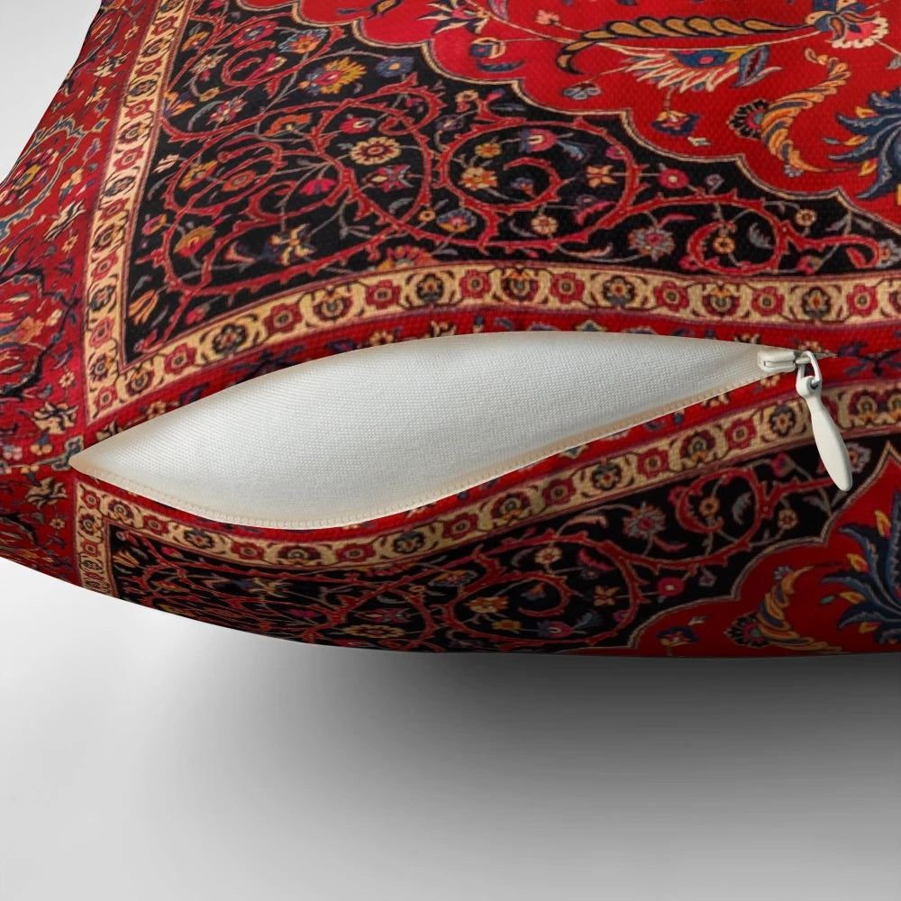 Closeup of a vibrant red Persian-style area rug pillow with intricate floral and geometric patterns.