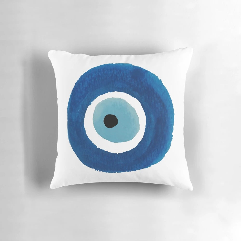 Vibrant watercolor painting of an evil eye (nazar) talisman on a decorative throw pillow.