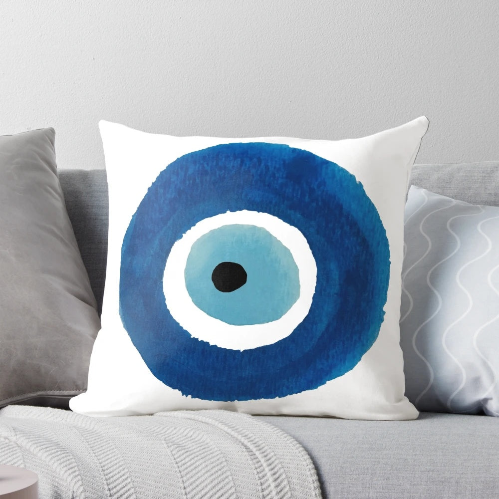 Vibrant watercolor painting of an evil eye (nazar) talisman on a decorative throw pillow.