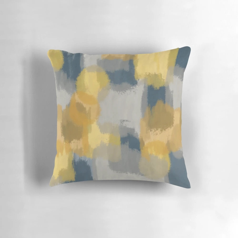 Handpainted abstract pattern in shades of mustard yellow, grey, and navy blue on a throw pillow