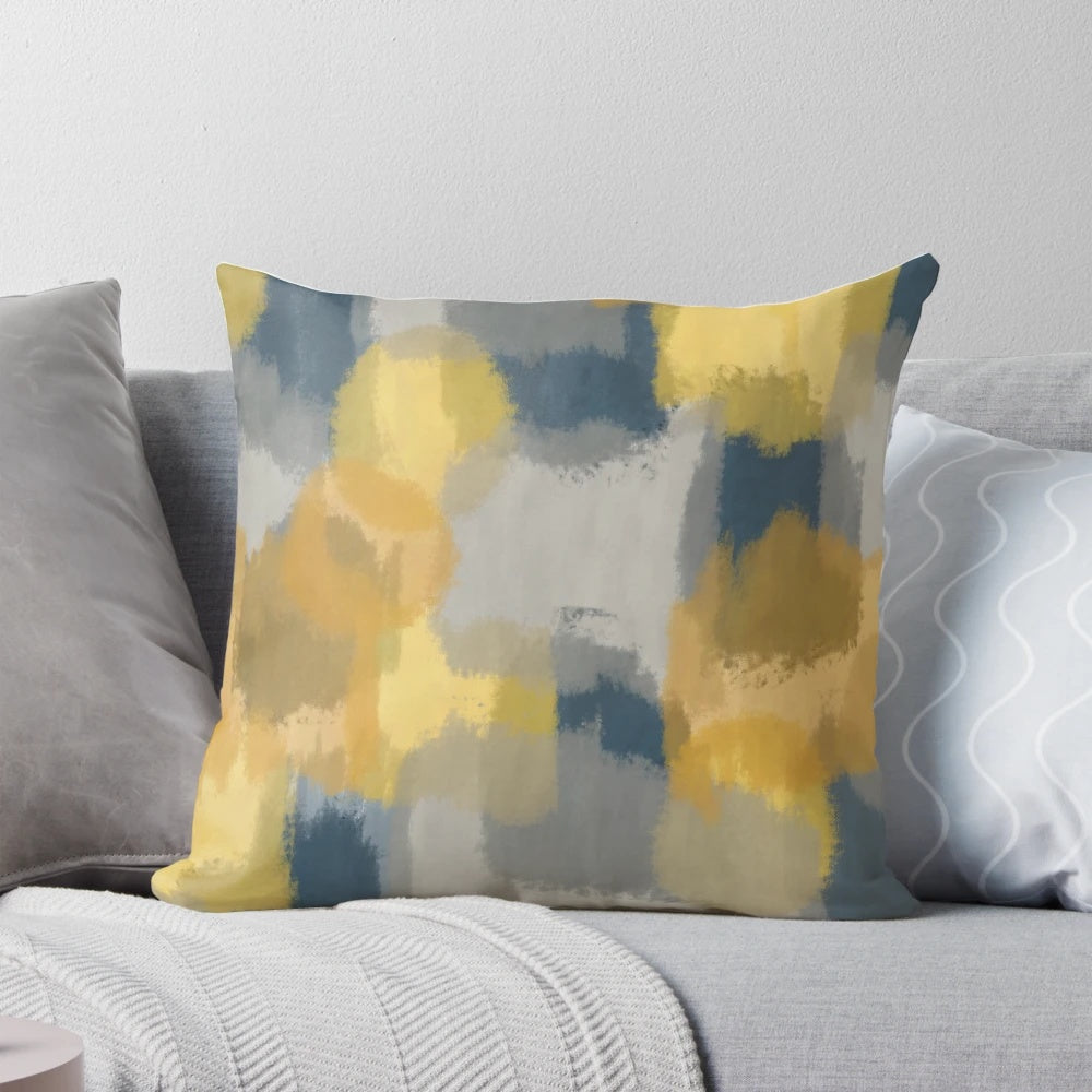 Handpainted abstract pattern in shades of mustard yellow, grey, and navy blue on a throw pillow