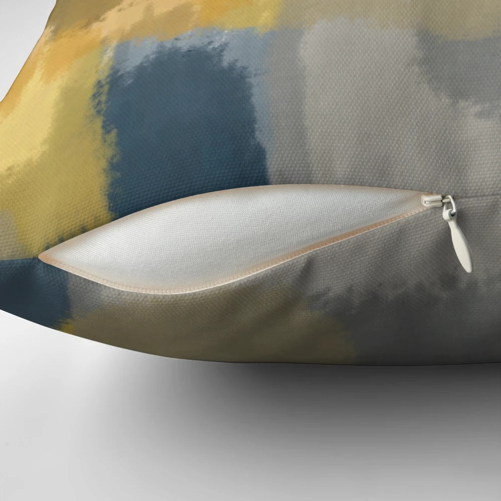 Handpainted abstract pattern in shades of mustard yellow, grey, and navy blue on a throw pillow