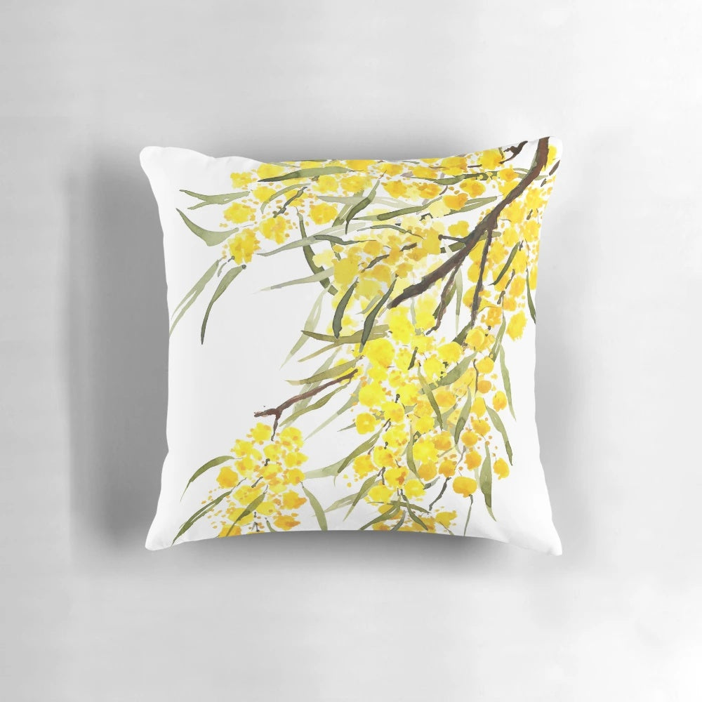 Watercolor painting of a golden wattle flower, a native Australian plant, on a decorative throw pillow.