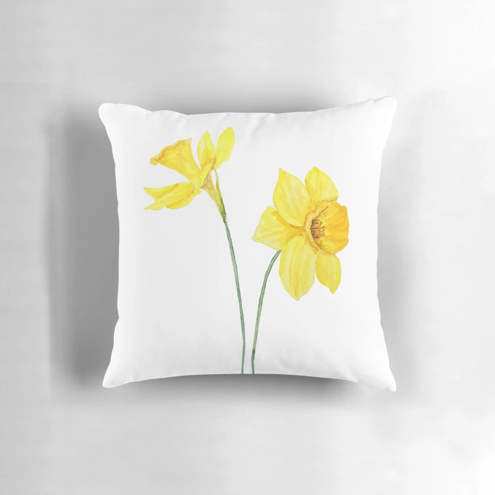 A vibrant hand painted watercolor painting of yellow daffodils flowers on a throw pillow for spring botanical decor.
