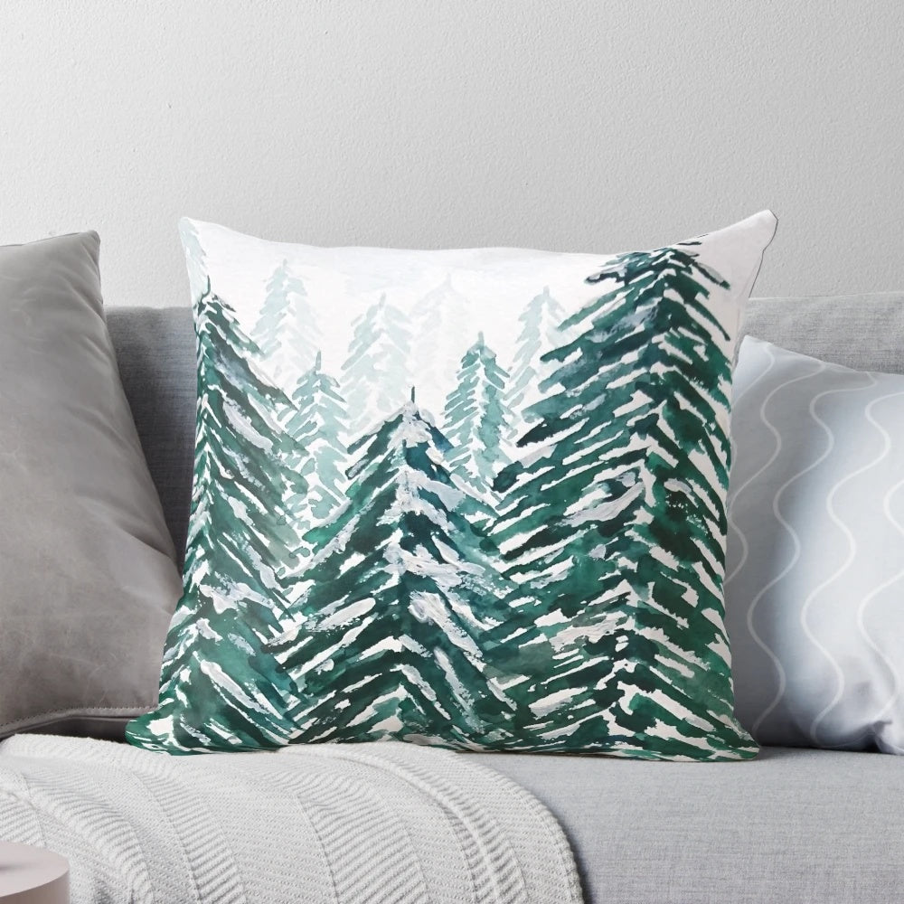 Handpainted green and white pillow with a snowy pine forest landscape design