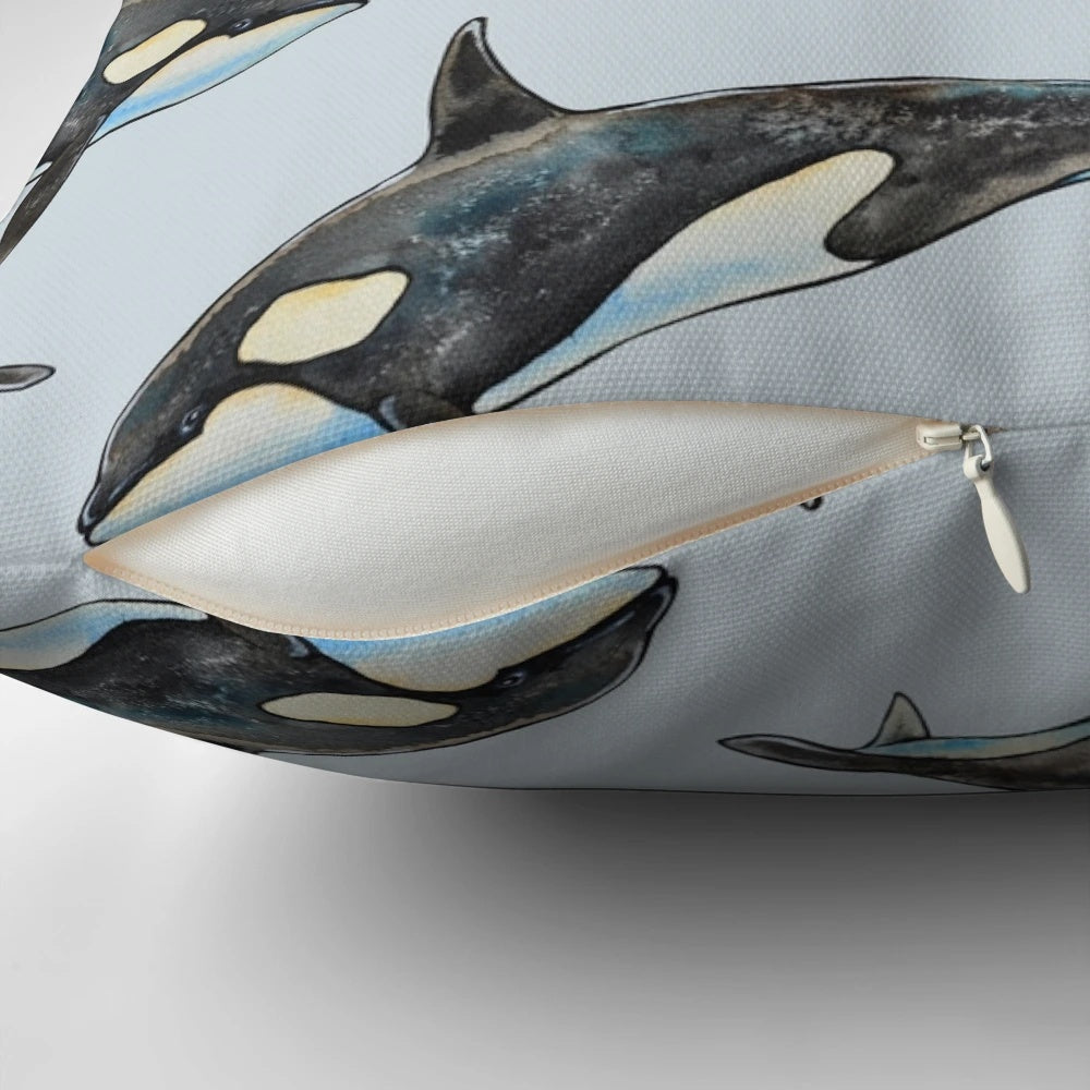 A beautifully hand-painted watercolor illustration of an orca whale on a blue background, featured on a decorative pillow.