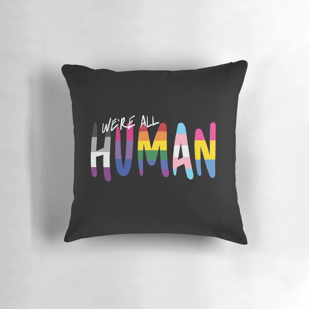 Colorful handwritten pride flags in stripes on a soft pillow, showcasing LGBTQIA+ identity and inclusivity.