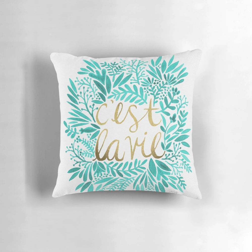 Turquoise and gold throw pillow with handwritten "That's Life" quote and floral design