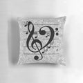 A grey pillow with a heart-shaped design featuring musical notes, treble and bass clefs, and other music symbols.