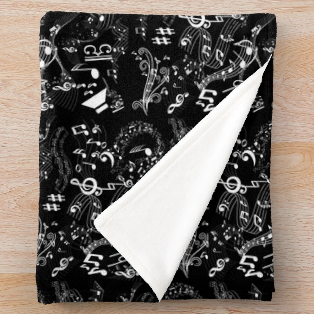 Plush blanket featuring a graphic art design of musical notation elements including treble clef, bass clef, and musical notes