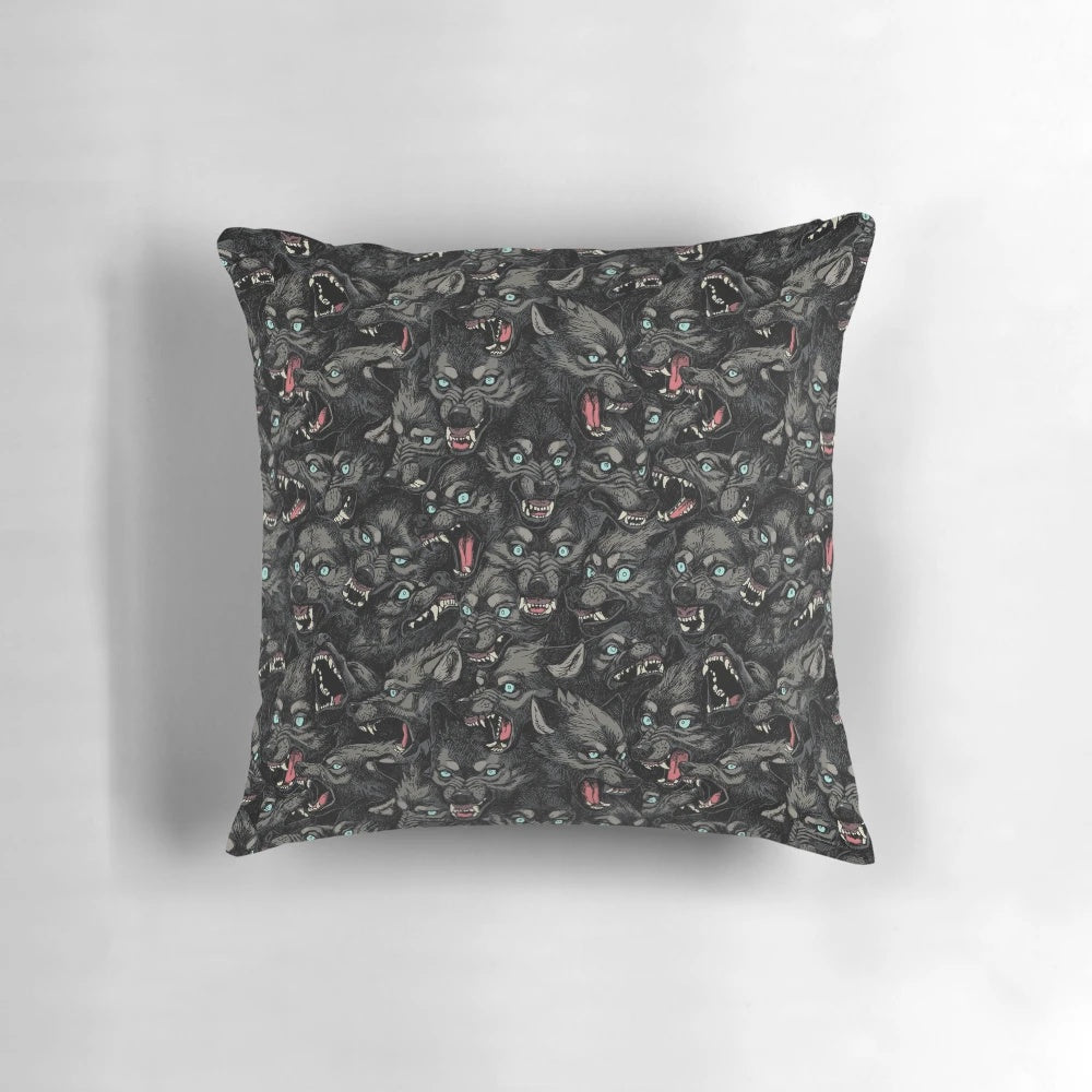 A grey and black wolf pack pattern pillow with snarling timber wolves
