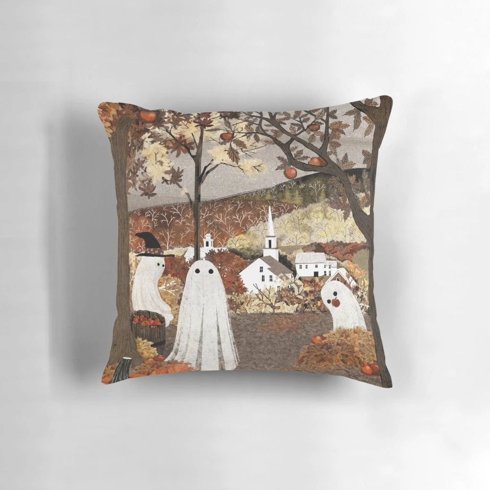 A cozy, autumn-themed pillow featuring a haunted orchard landscape with ghost, pumpkins, and falling leaves.