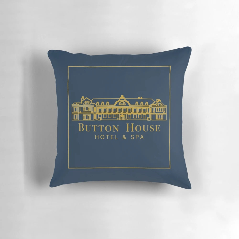 Pillow with Button House Hotel and Spa logo, featuring ghosts and haunted house elements