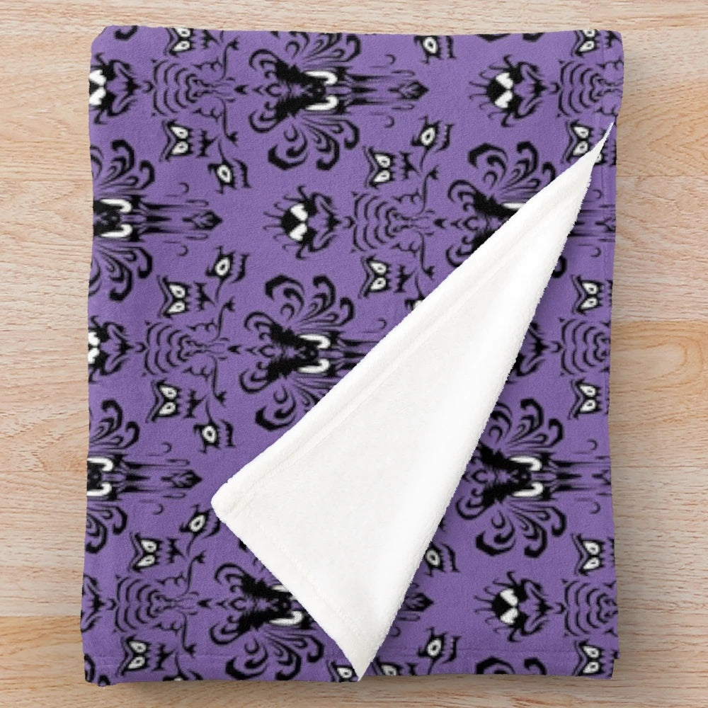 Haunted-inspired plush blanket with ghost and creepy decor elements