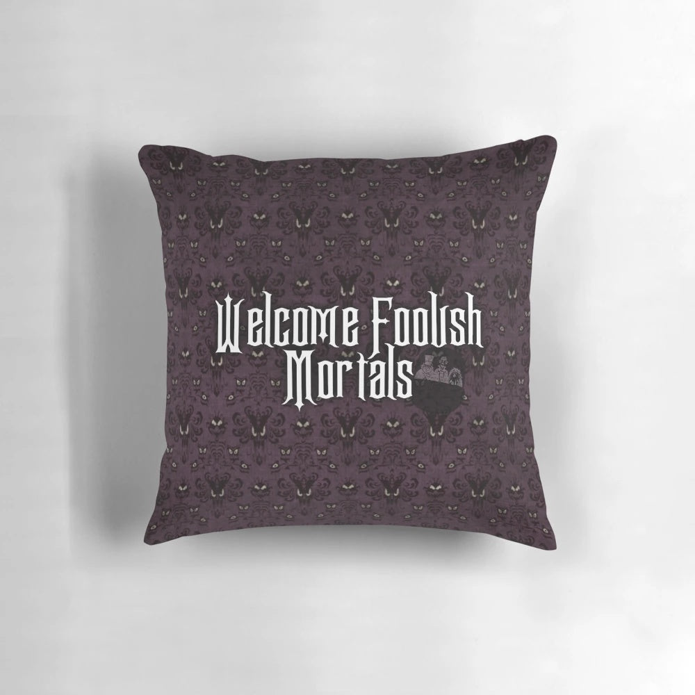 A cozy pillow featuring the "Welcome Foolish Mortals" text from the Haunted Mansion ride at Disney parks.
