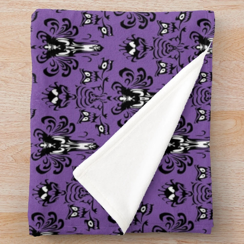 Haunted mansion plush blanket featuring gothic inspired wallpaper design