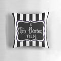 A black and white striped throw pillow with a gothic, eerie vibe, inspired by the films of Tim Burton