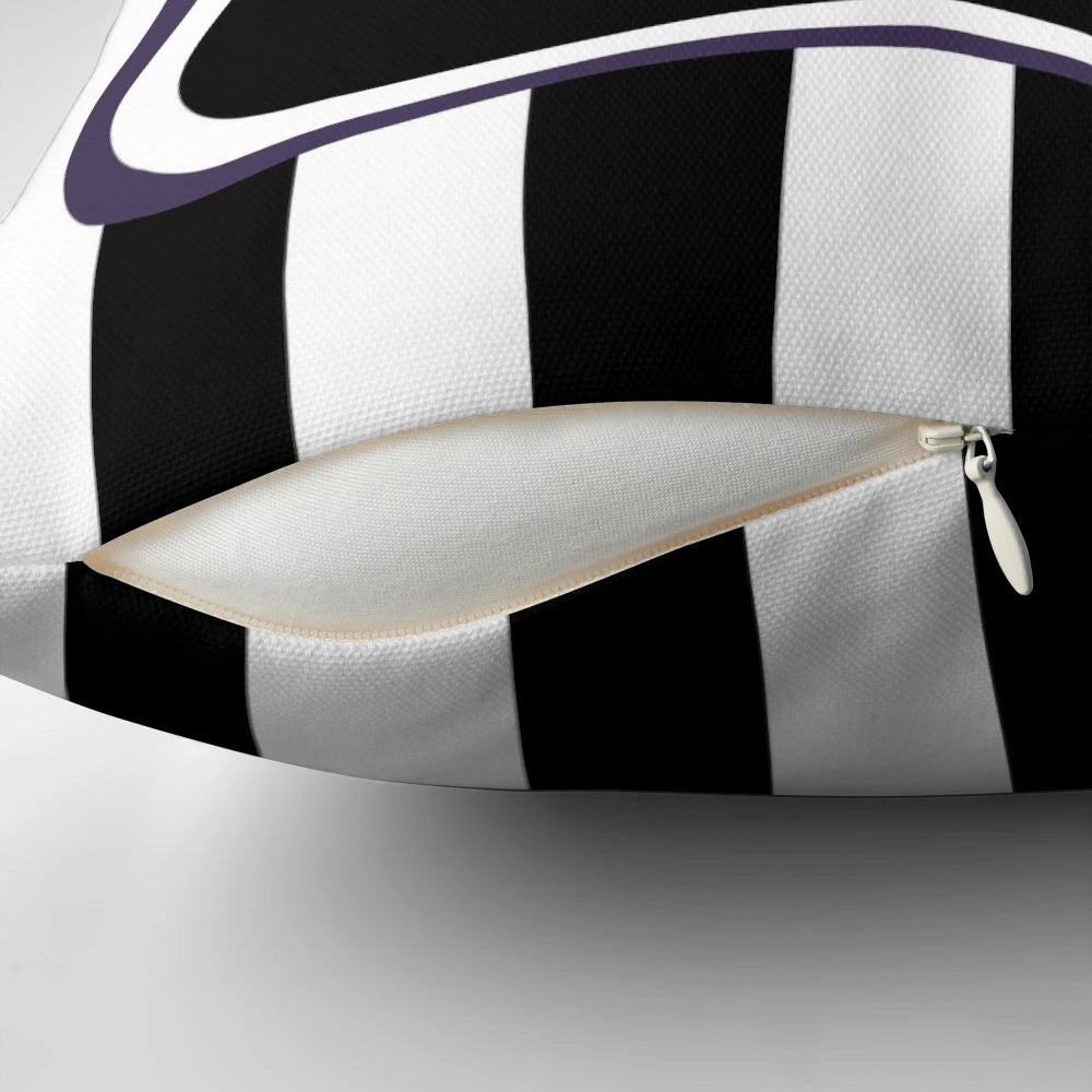 A black and white striped throw pillow with a gothic, eerie vibe, inspired by the films of Tim Burton