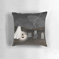 A pillow featuring a haunted graveyard scene with ghostly lanterns, lightning, and gravestones.