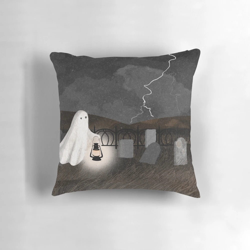 A pillow featuring a haunted graveyard scene with ghostly lanterns, lightning, and gravestones.