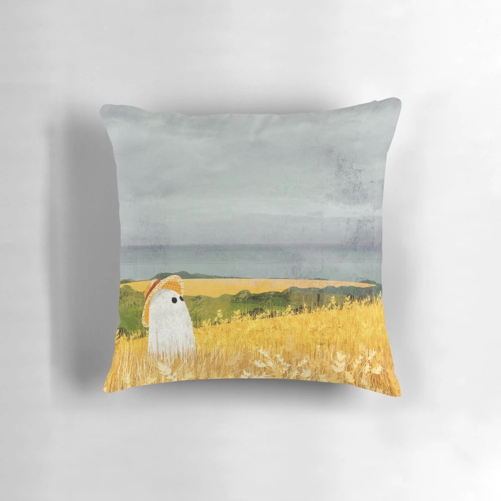 Pillow with a ghostly figure in a picturesque wheat field landscape