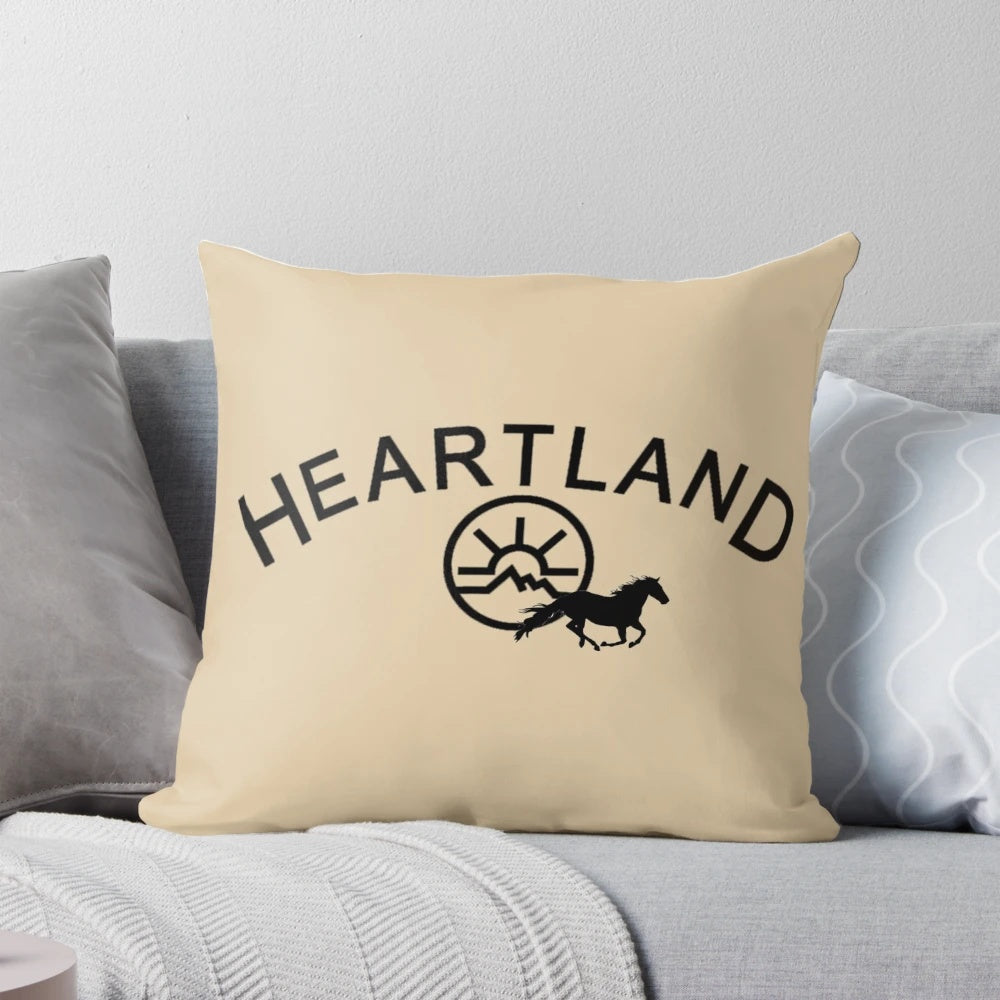 A black pillow with the Heartland TV show logo, featuring horses and the Montana landscape.