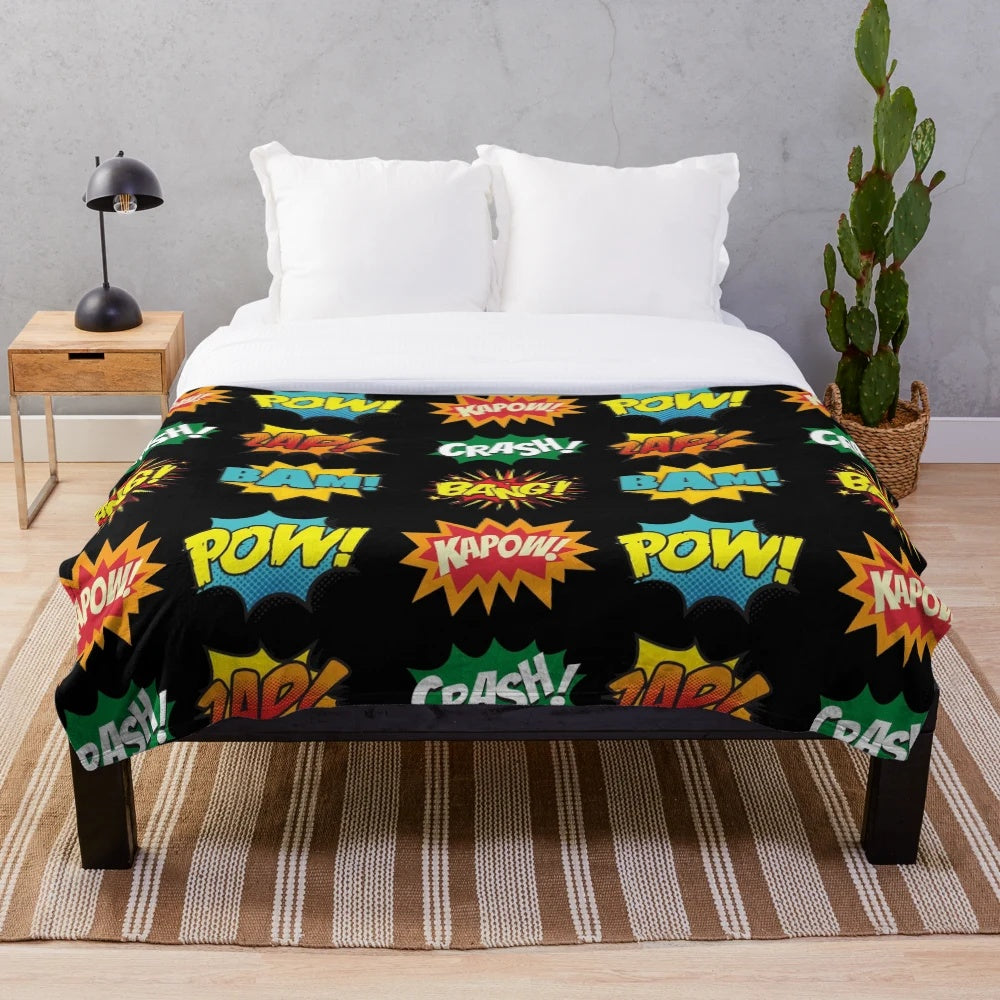 Plush blanket featuring comic book-inspired onomatopoeia sounds and superhero graphics