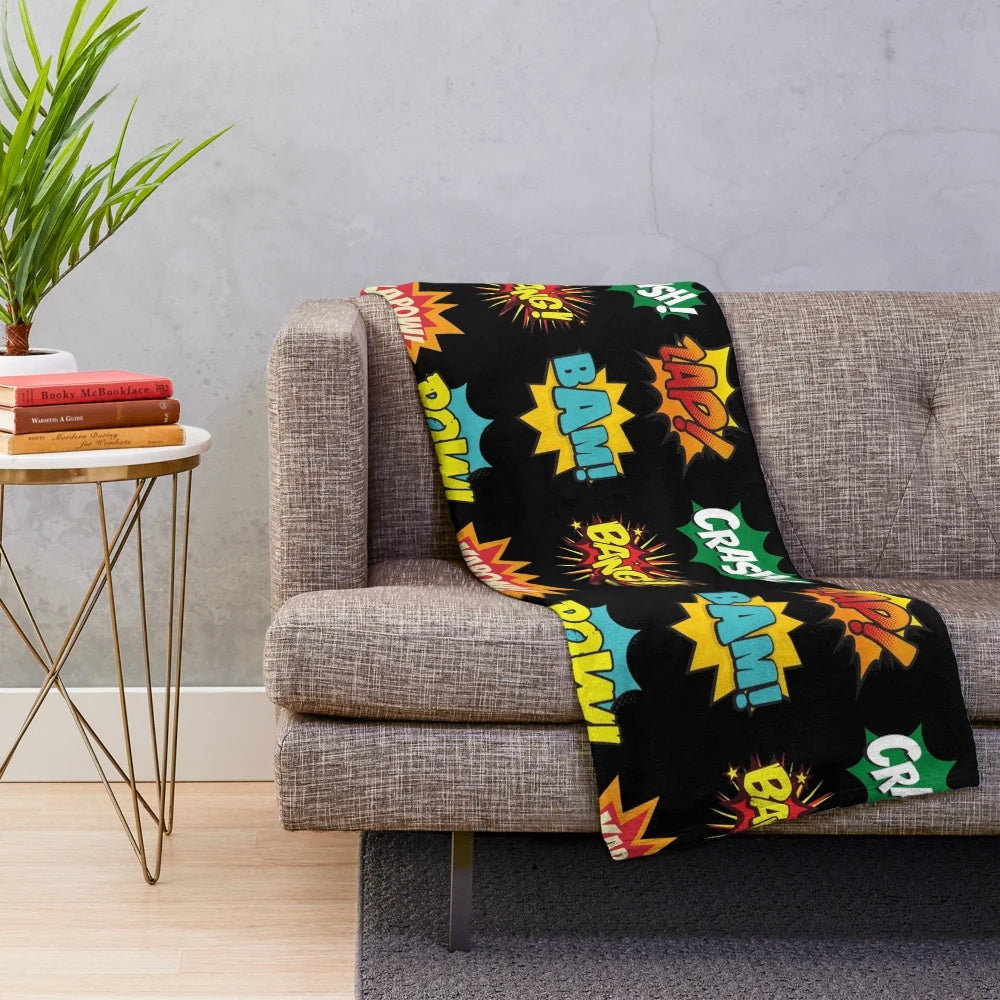 Plush blanket featuring comic book-inspired onomatopoeia sounds and superhero graphics