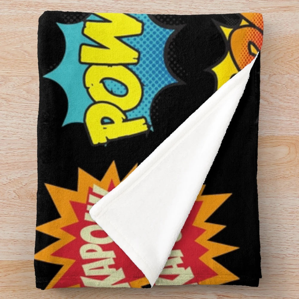 Plush blanket featuring comic book-inspired onomatopoeia sounds and superhero graphics