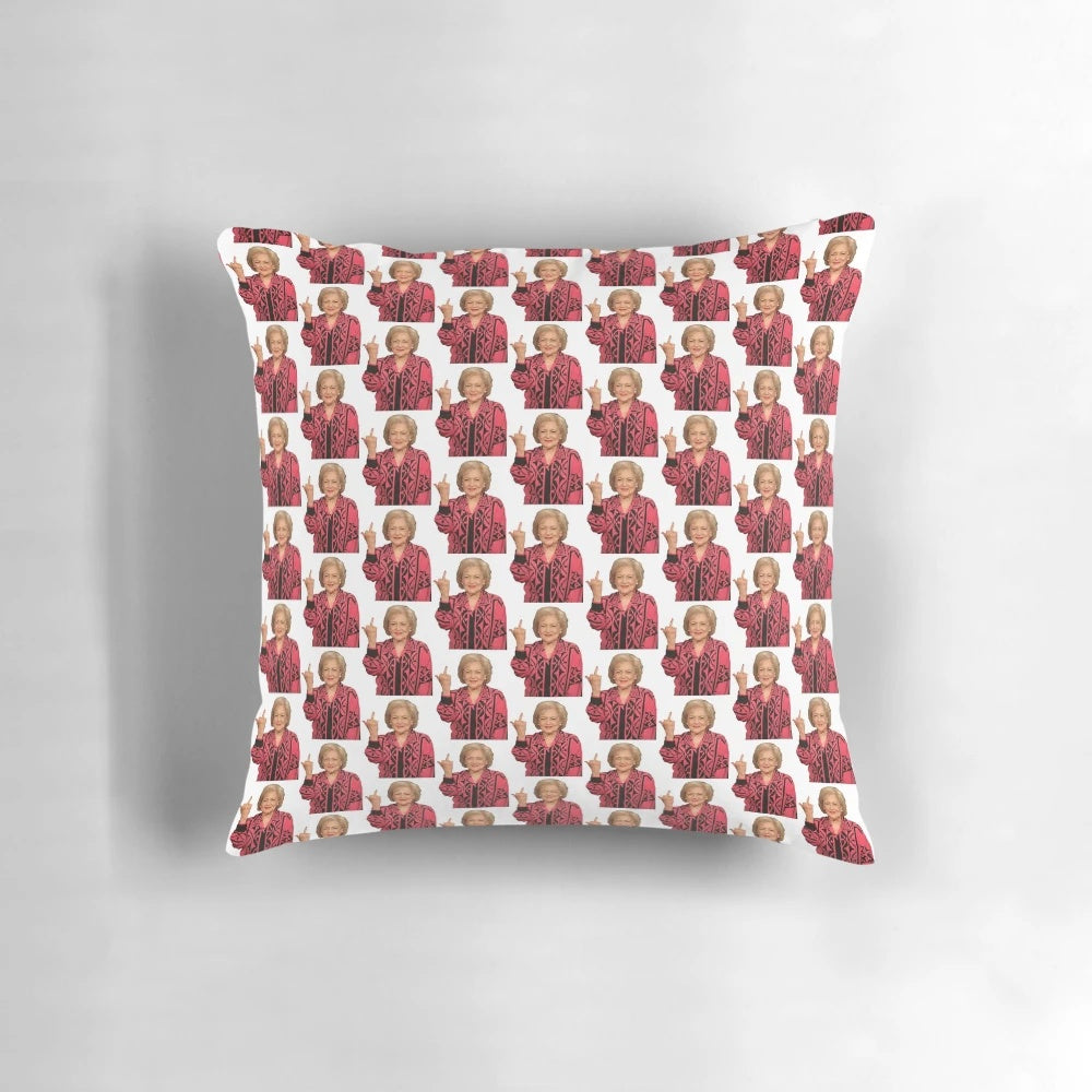 A playful pillow featuring a photo of legendary actress Betty White giving the middle finger, a humorous and sarcastic home decor item.