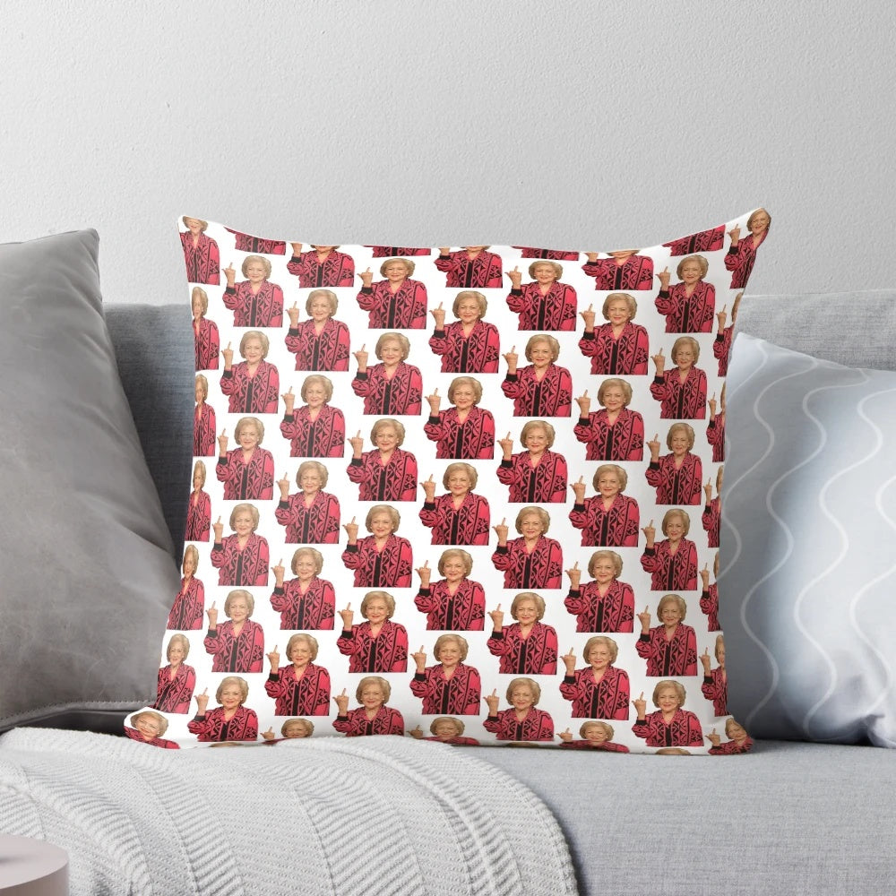 A playful pillow featuring a photo of legendary actress Betty White giving the middle finger, a humorous and sarcastic home decor item.