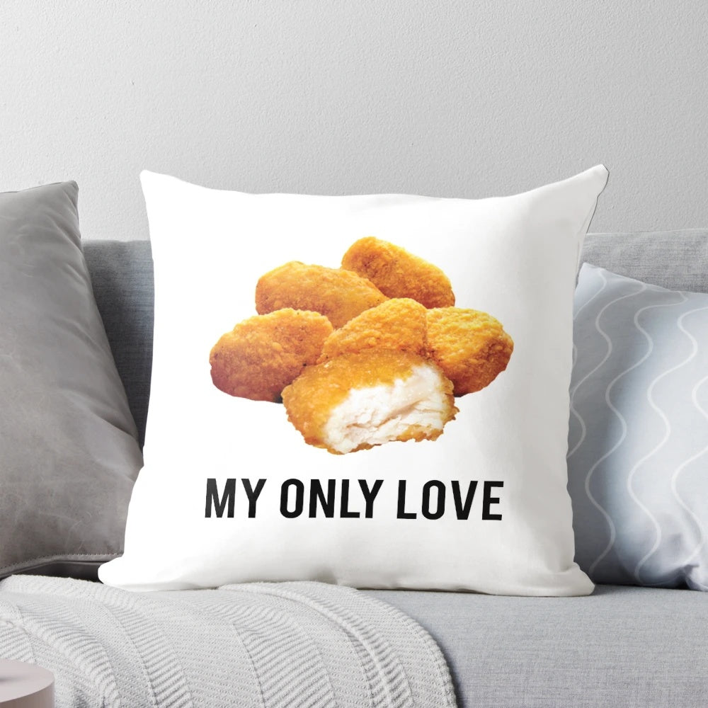 A white, square pillow with the text "chicken nuggets my only love" printed on it.