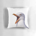 A white and yellow seagull with an open beak screaming on a pillow.