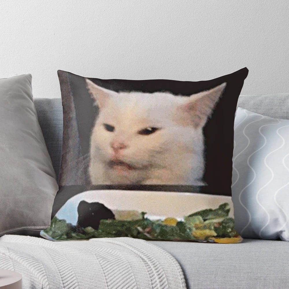 Pillow with image of woman shouting at a confused cat sitting on a table