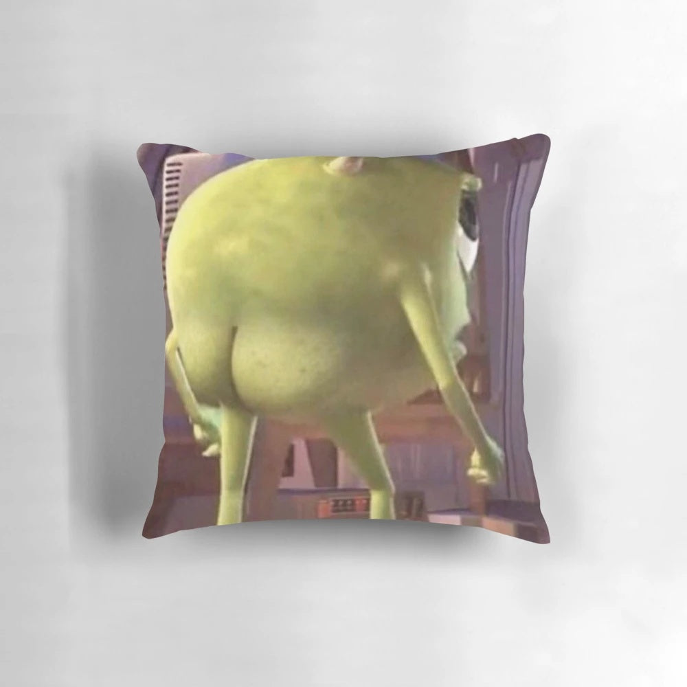 A green, cartoonish pillow with the face of the popular Monster Inc. character Mike Wazowski printed on it.