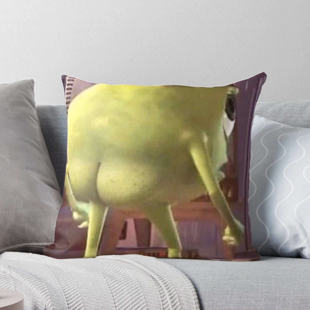 A green, cartoonish pillow with the face of the popular Monster Inc. character Mike Wazowski printed on it.