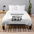 Plush blanket with a humorous "I may snap" warning design