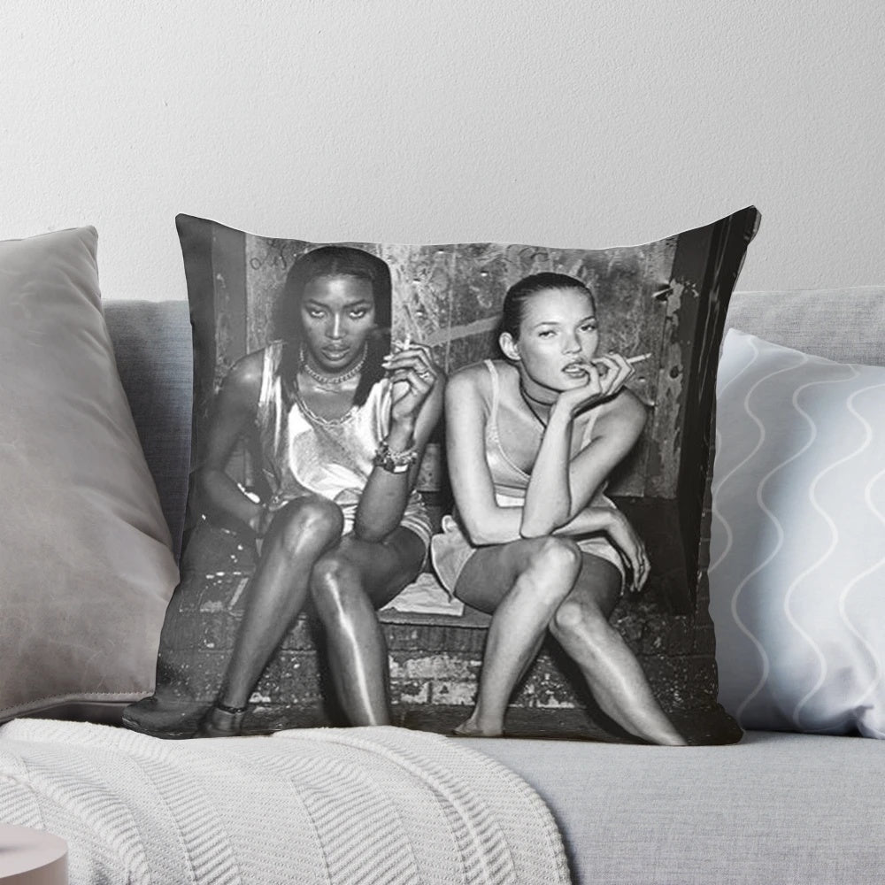 Black and white photograph of 90s supermodels Naomi Campbell and Kate Moss posing together on a pillow.