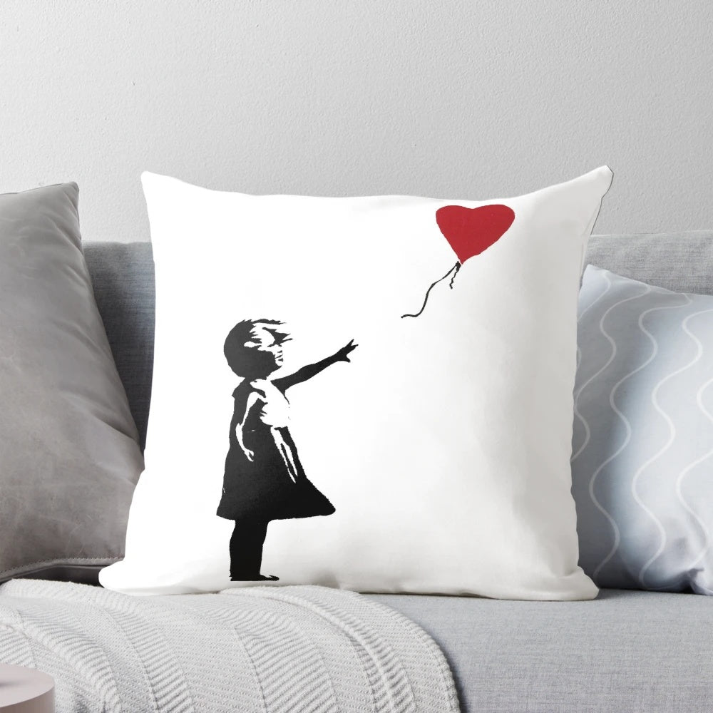 Decorative pillow featuring the iconic Banksy street art image of a girl reaching for a heart-shaped balloon.