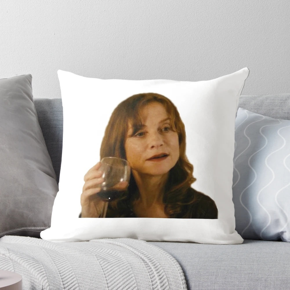 Isabelle Huppert, the renowned French actress, enjoying a glass of wine on a decorative pillow.