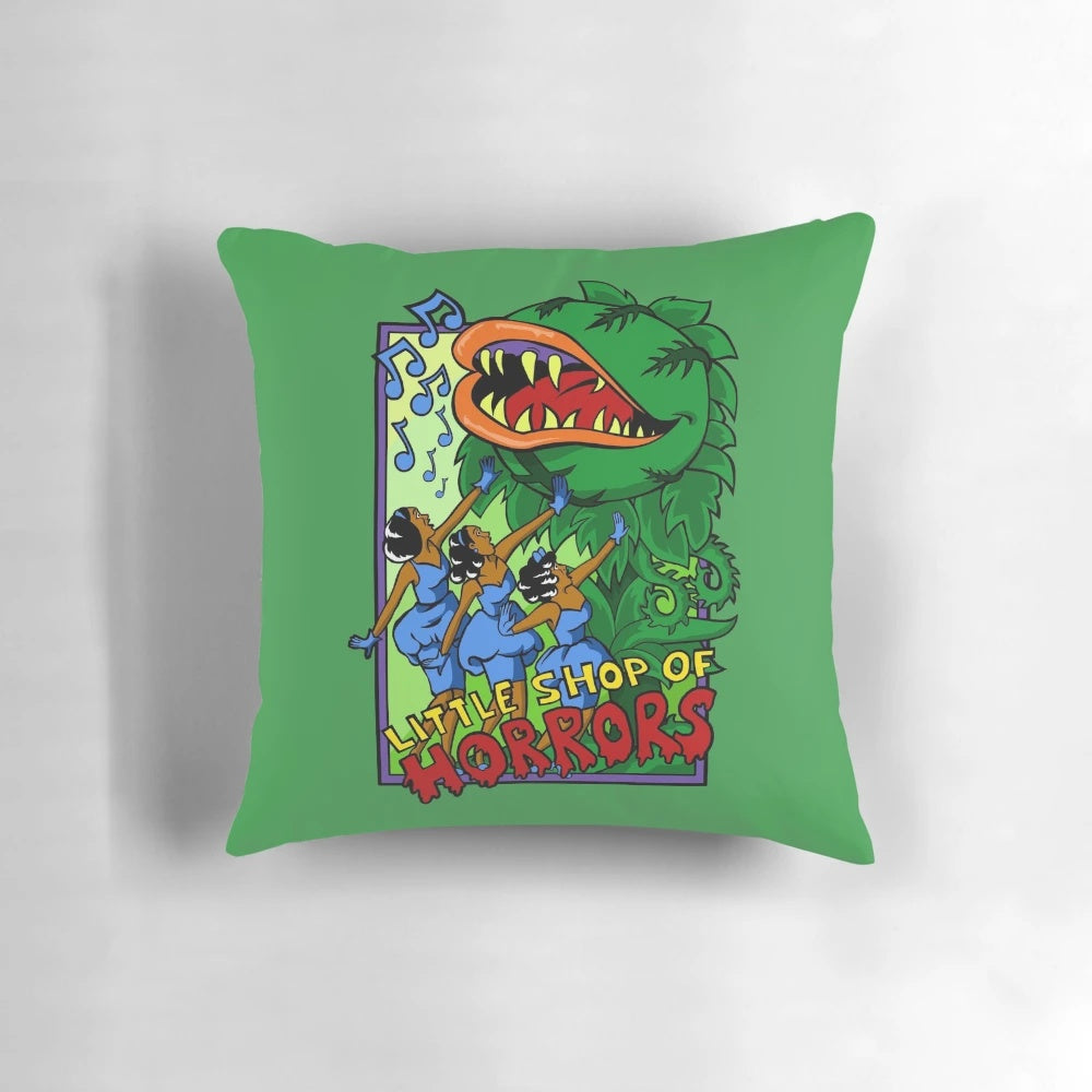 A plush throw pillow featuring the classic "Little Shop of Horrors" design, including Audrey II and the urchins.