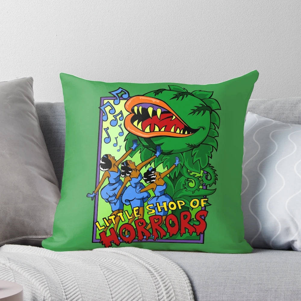 A plush throw pillow featuring the classic "Little Shop of Horrors" design, including Audrey II and the urchins.