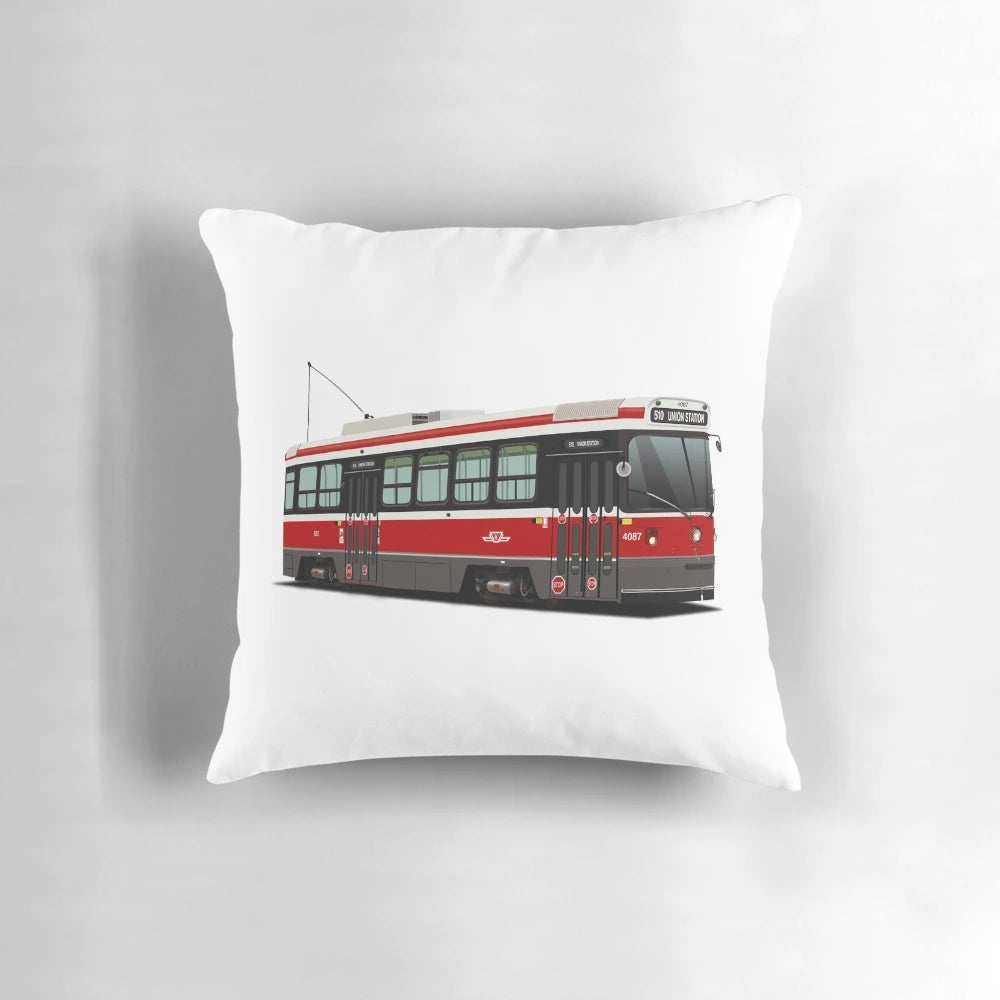 Pillow featuring an illustration of a classic Toronto streetcar in red, white, and grey.