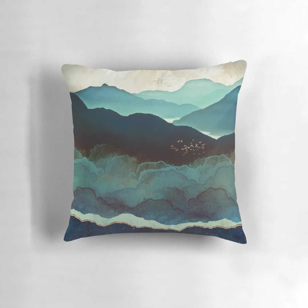 Indigo Mountain Landscape Pillow featuring a contemporary watercolor design of mountains, birds, and a blue and gold color palette.