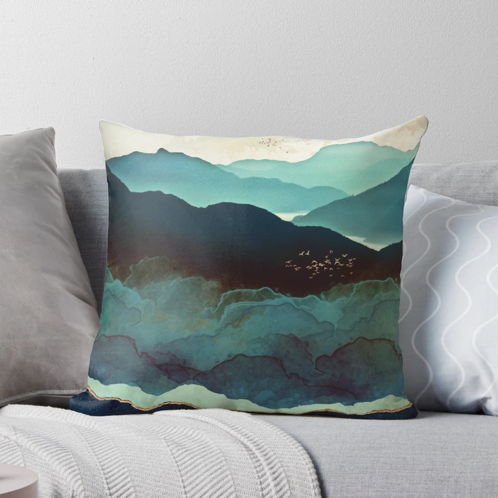 Indigo Mountain Landscape Pillow featuring a contemporary watercolor design of mountains, birds, and a blue and gold color palette.